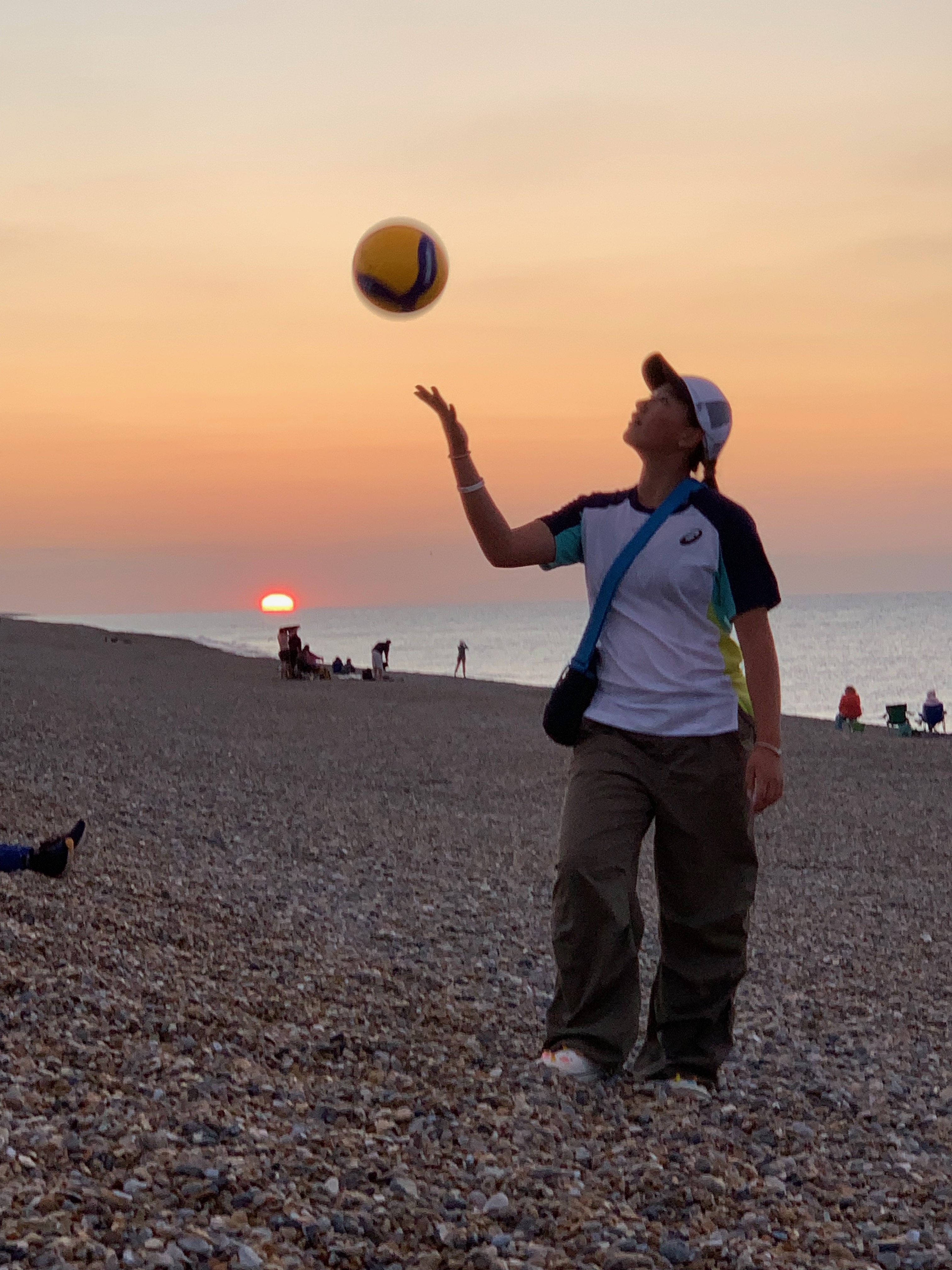 Sunset on beach with person throwing volleyball